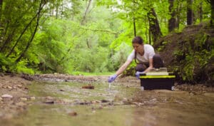 technicienne qui analyse la qualité de l'eau d'une rivière